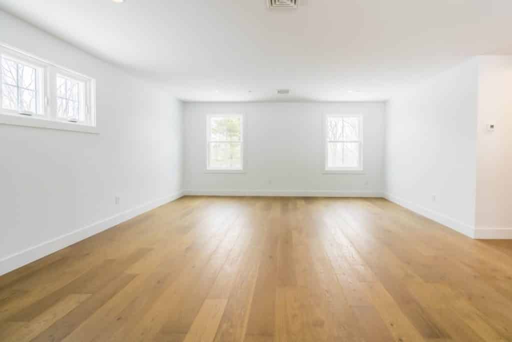 A large, empty room with white walls and a hardwood floor.