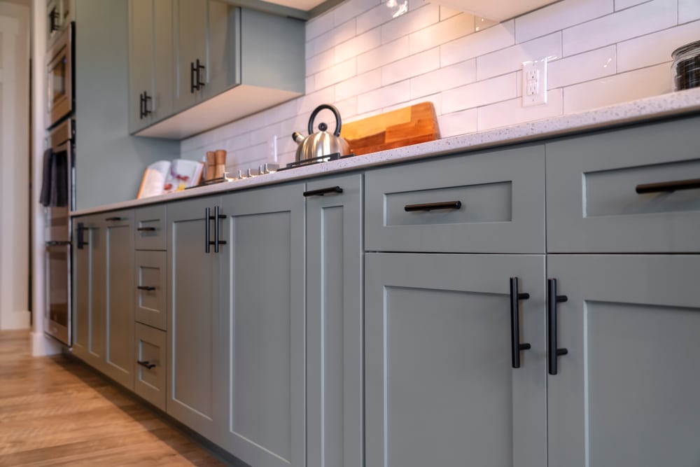 grey kitchen cabinets with white tile backsplash