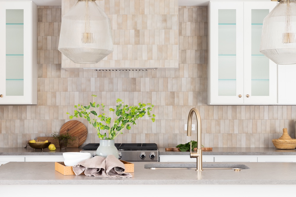 kitchen with brown tile backsplash and white cabinets